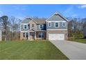 Charming two-story home featuring a brick and siding facade and a pristine front lawn at 127 Felicity Pike, Locust Grove, GA 30248
