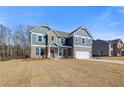 Well-designed two-story home showcasing brick accents, siding and an attached two-car garage at 127 Felicity Pike, Locust Grove, GA 30248