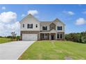 Charming two-story home with manicured front lawn, a two-car garage, and a combination brick and siding exterior at 127 Felicity Pike, Locust Grove, GA 30248