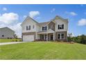 Attractive two-story home boasting a lush lawn, a two-car garage, and a blend of brick and siding at 127 Felicity Pike, Locust Grove, GA 30248