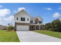 Stunning two-story home with manicured lawn, a two-car garage, and a brick and siding exterior at 127 Felicity Pike, Locust Grove, GA 30248