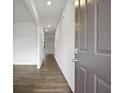 Inviting hallway with wood-look flooring and neutral paint leading to various rooms in the home at 8233 Walnut Hall Dr, Fairburn, GA 30213
