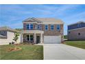 Charming two-story brick home with a covered porch and attached two-car garage at 132 Dalston Cv, Stockbridge, GA 30281