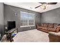 Cozy bedroom with neutral carpet, ceiling fan, and a comfortable seating area at 1921 Boulder Gate Dr, Ellenwood, GA 30294