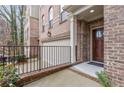 Brick townhome entrance featuring manicured landscaping and a black wrought iron fence at 2363 Palladian Manor Se Way # 4, Atlanta, GA 30339