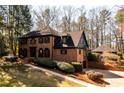 Brick home features dark shutters, a large driveway, and mature trees at 1435 Jay Ct, Snellville, GA 30078
