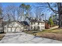 Charming two-story home with a long driveway surrounded by mature trees and lush greenery at 2958 Cravey Ne Dr, Atlanta, GA 30345