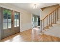 Open foyer with hardwood floors, staircase with iron spindles, neutral paint, and glass panel front doors at 2958 Cravey Ne Dr, Atlanta, GA 30345