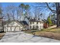 Beautiful two-story home with a large driveway, dormer windows, neutral colors, and mature trees at 2958 Cravey Ne Dr, Atlanta, GA 30345