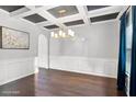Formal dining area features coffered ceilings, wainscoting, hardwood floors, and a contemporary chandelier at 3975 Silverthorn Trce, Cumming, GA 30028