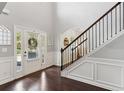 Bright foyer with dark wood floors, staircase with metal spindles, and view to a front door at 3975 Silverthorn Trce, Cumming, GA 30028