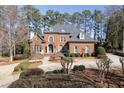 Charming two-story brick home featuring a well-manicured lawn, mature trees, and a basketball court at 2821 Grey Moss Pass, Duluth, GA 30097
