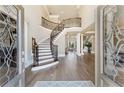 Grand foyer featuring a curved staircase with wrought iron railings and gleaming hardwood floors at 2821 Grey Moss Pass, Duluth, GA 30097