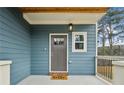 A welcoming front porch with a gray door, stylish lighting, and a friendly 'hello' doormat at 3143 Stonegate Sw Dr, Atlanta, GA 30331