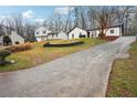 Exterior view of a home with a long driveway leading up to the property on a hillside at 5151 Martins Crossing Rd, Stone Mountain, GA 30088