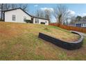 This home features a stone facade, a black front door, and a grass yard on a sloped lot at 5151 Martins Crossing Rd, Stone Mountain, GA 30088