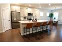 Modern kitchen featuring an island with seating, stainless steel appliances, and sleek countertops at 221 Begonia Way, Mcdonough, GA 30253