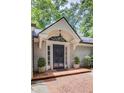 Elegant front door with decorative trim and brick walkway, complemented by potted plants and lush landscaping at 366 Blackland Nw Rd, Atlanta, GA 30342