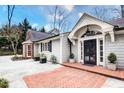 Stately home with a brick walkway leading to a covered entrance with manicured landscaping at 366 Blackland Nw Rd, Atlanta, GA 30342