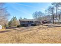 Charming ranch home featuring a spacious porch and classic architectural details on a sunny day at 1315 Woodland Sw Dr, Oxford, GA 30054