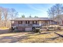 Charming ranch home featuring a spacious porch and classic architectural details on a sunny day at 1315 Woodland Sw Dr, Oxford, GA 30054