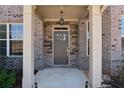 Close up of the home's front entryway with stone accents, gray door, and white columns at 590 Palm Springs Cir, Fairburn, GA 30213
