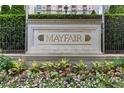 Close-up view of the 'Mayfair' sign, complemented by blooming flowers and greenery at 199 14Th Ne St # 1704, Atlanta, GA 30309