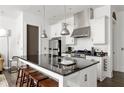 Bright kitchen boasts stainless steel appliances, granite countertops, large island with bar stool seating at 9121 Selborne Ln, Chattahoochee Hills, GA 30268