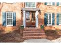 Inviting front entrance with brick steps, wooden double doors, and charming flower pots at 4335 Halifax Ne Ter, Roswell, GA 30075