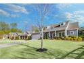 Lovely single Gathering home with a green lawn and a beautiful tree in the front yard at 302 Canter Way, Woodstock, GA 30188