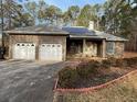 Charming brick house with a two-car garage, solar panels, and a well-manicured front yard at 5207 W Shore Sw Dr, Conyers, GA 30094