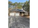 Brick ranch-style home featuring an attached two-car garage, solar panels, and mature landscaping at 5207 W Shore Sw Dr, Conyers, GA 30094