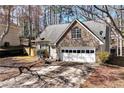 Charming home featuring stone accents, a two-car garage and well-manicured landscaping at 5532 Riverside Dr, Sugar Hill, GA 30518