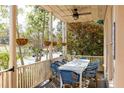 View of a screened porch with dining table and chairs and ceiling fan at 10528 Serenbe Ln, Chattahoochee Hills, GA 30268