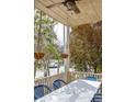 Covered porch with chairs, table and ceiling fan overlooking the landscape at 10528 Serenbe Ln, Chattahoochee Hills, GA 30268