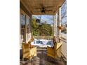 View of a covered porch with porch swing, chairs and pillows at 10528 Serenbe Ln, Chattahoochee Hills, GA 30268