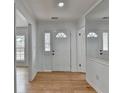Bright foyer featuring hardwood floors, white walls, and a front door with decorative window and transom at 1284 Warsaw Rd, Roswell, GA 30076