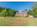 Beautiful two-story brick home with a lush green lawn and mature trees at 104 Sunflower Meadows Dr, Mcdonough, GA 30252