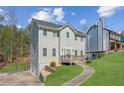 Two-story home with gray siding, landscaped lawn, and a driveway leading to a garage at 972 Oakley Ln, Sugar Hill, GA 30518