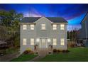 Charming two-story home with gray siding, a new roof, and landscaped lawn at dusk at 972 Oakley Ln, Sugar Hill, GA 30518