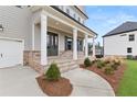 Inviting front porch with brick accents, sturdy white columns, and well-maintained landscaping at 5424 Gallagher Ct, Powder Springs, GA 30127