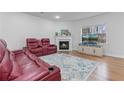 Cozy living room with comfortable leather recliners, a fireplace, a large window, and hardwood floors at 5915 Pinnacle View Rd, Cumming, GA 30040