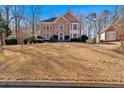 Landscaped front yard leading to a two-story brick home under a bright blue sky at 3699 Fowler Rdg, Douglasville, GA 30135