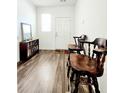 Inviting entryway with wood-look floors, a dark wood bookcase, and two bar stools by the door at 6408 Kennonbriar Ct, Lithonia, GA 30058