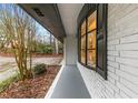 Side view of updated brick home with black framed windows and mature landscaping at 3367 Spring Meadow Ct, Tucker, GA 30084