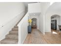 Inviting foyer with staircase, wood flooring, arched entryway, and view to the kitchen and living area at 461 Charleston Pl, Villa Rica, GA 30180