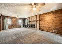 Spacious living room features a brick fireplace, carpet and wood paneling creating a cozy and inviting atmosphere at 4722 Bexley Dr, Stone Mountain, GA 30083