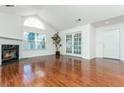 Open living room with hardwood floors, fireplace, and French doors at 2406 Village Ln, Roswell, GA 30075