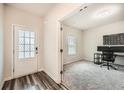 Bright entryway featuring hardwood-style floors and a view into a carpeted office space at 4929 Dufour Dr, Lilburn, GA 30047