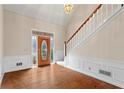 Inviting foyer featuring hardwood floors, wainscoting, stairs to the upper level and a beautiful front door at 10625 Haynes Forest Dr, Alpharetta, GA 30022